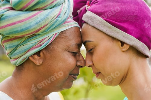 Preview: African mother and daughter having tender moment wearing head scarf and traditional clothes