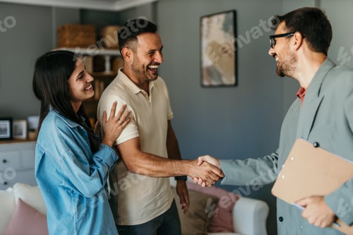 Preview: Real estate agent shaking hands with happy couple