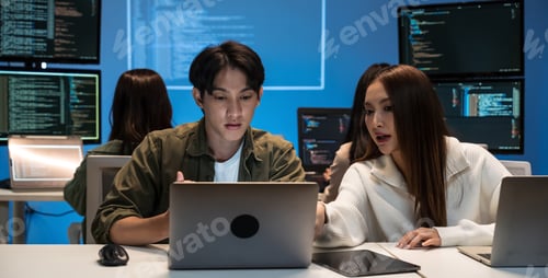 Preview: Young Asian business team working late on coding and brainstorming ideas