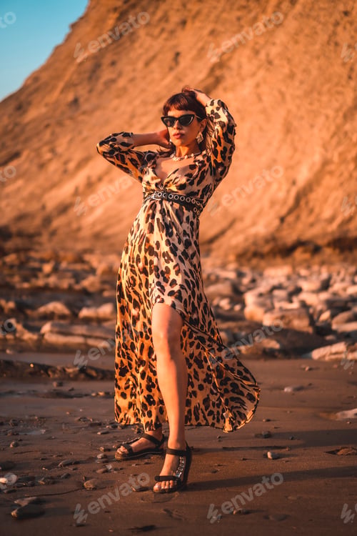 Preview: Summer lifestyle on a beach next to rocks of a young brunette Caucasian woman