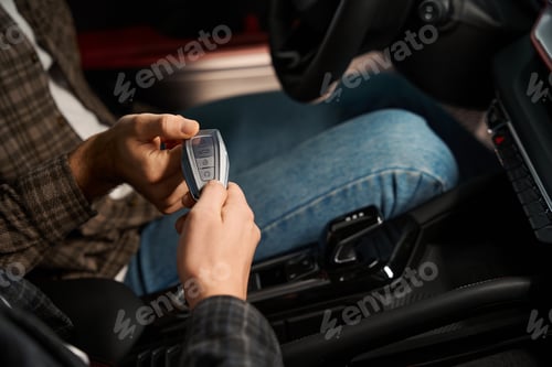 Preview: Salesman in dealership giving key to man new car owner