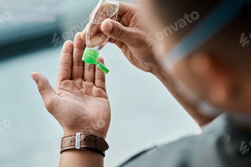 Preview: Cropped shot of a businessman using hand sanitiser to disinfect his hands
