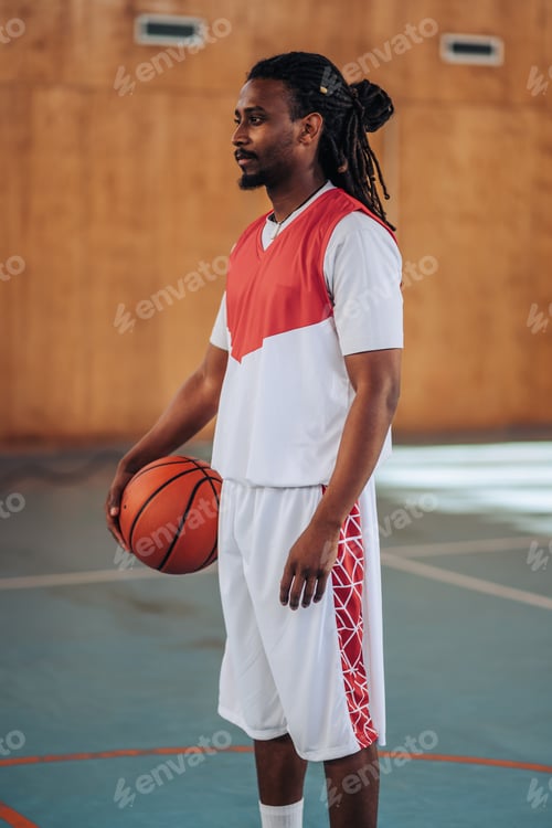 Preview: A fit muscular interracial basketball player on court with ball.