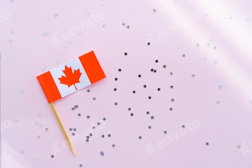 Preview: Canada flag and sparkles on pink background, flat lay. Holiday in Canada.