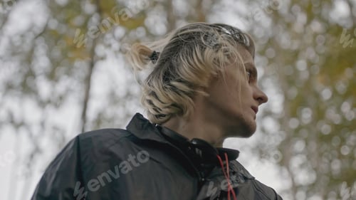 Preview: Man wanders in forest and looks around anxiously. Stock. Young man walks in woods with phone and