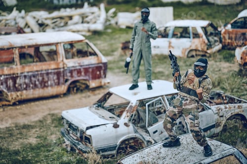 Preview: Paintball, winner and celebration with a sports man on a car in a battlefield during army training