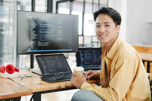 Preview: Young programmer working on desktop PC in office of software company.