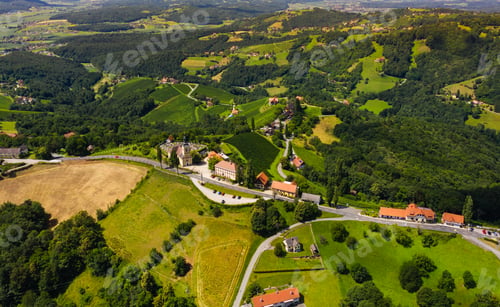 Preview: Aerial view of green hills and vineyards with mountains in background