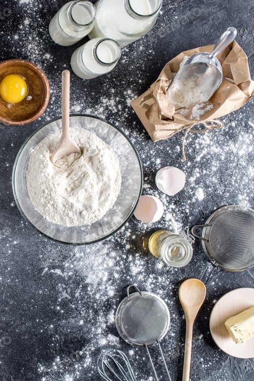 Preview: flat lay with flour and other ingredients for bakery, kitchenware on dark tabletop