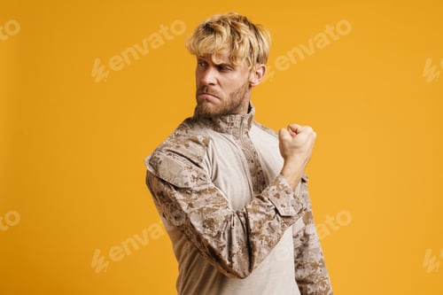 Preview: European military man wearing uniform showing his bicep at camera