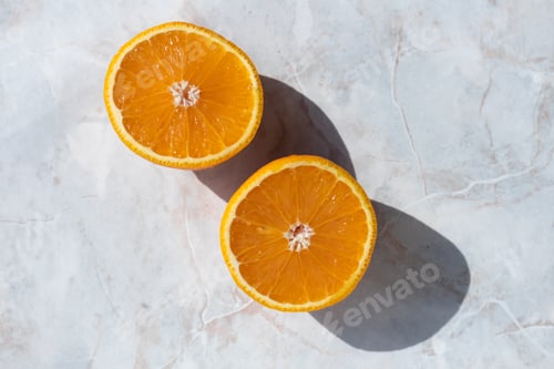 Preview: Halved orange on a light marbled table. Top view