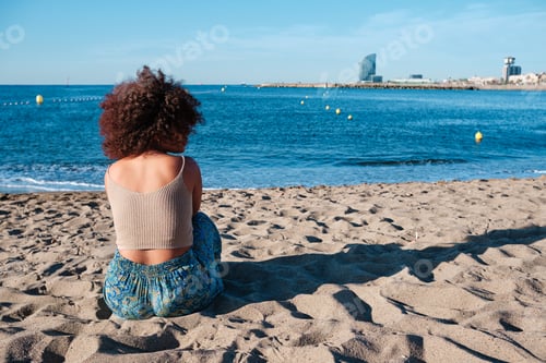 Preview: young afro woman at Barcelona beach early in the morning