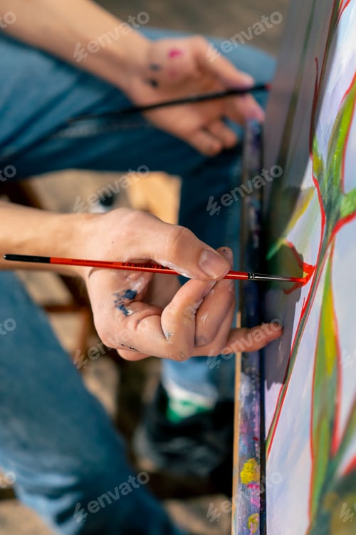 Preview: an art studio a painting with flowers the artist sitting the details on the painting with red paint