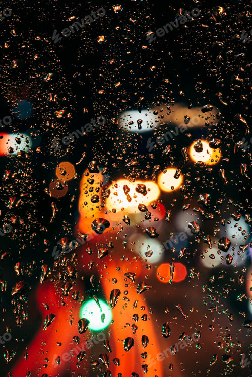Preview: Close up view of raindrops on window and bokeh city lights on background