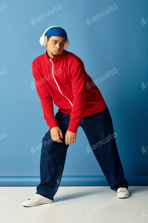 Preview: Stylish young african american man showcasing trendy fashion against a blue backdrop