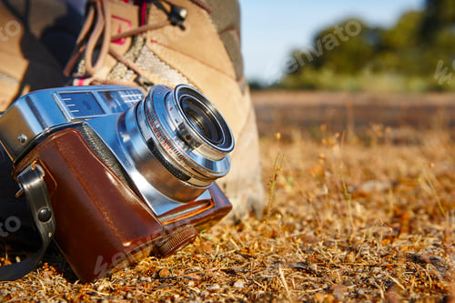 Preview: Vintage camera with hiking boots on the ground. Travel background