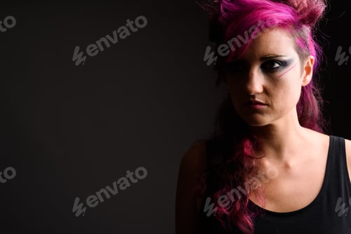 Preview: Beautiful woman with pink hair and make-up against gray backgrou