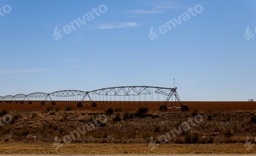 Preview: Pivot irrigation system sprinkler watering crops at farm land in the Arizona Desert.