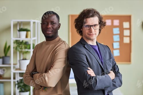 Preview: Two young men in office posing confidently and looking at camera