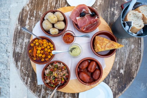 Preview: Spanish tapas selection featuring chorizo, patatas bravas, and iberian ham