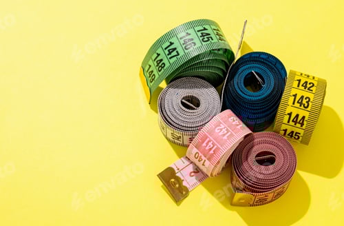 Preview: colorful measuring tapes high angle view on bright yellow background
