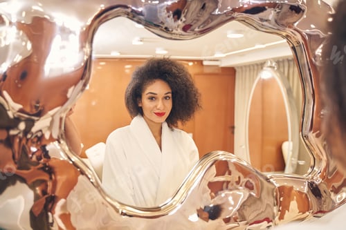 Preview: Gorgeous refrection of positive curly lady in spa parlor