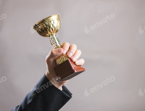 Preview: Hand of businessman holding Cup, concept success