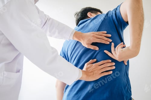 Preview: Doctor physiotherapist treating lower back pain patient after while giving exercising treatment on