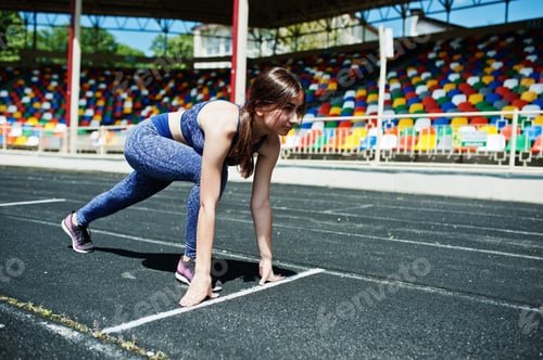 Preview: Portrait of a strong fit girl in sportswear running in the stadium.