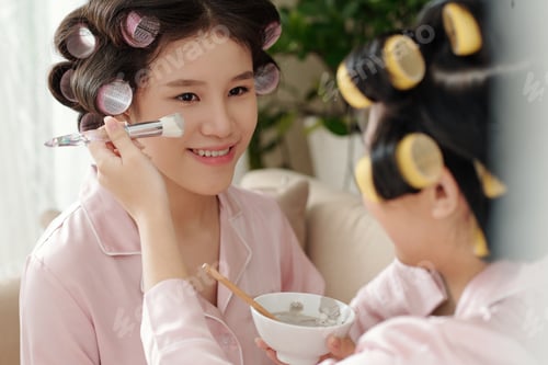 Preview: Young Women Applying Face Mask at Home