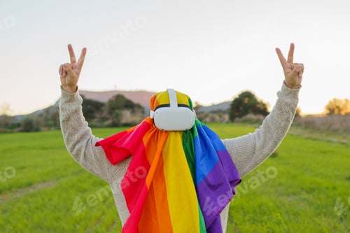 Preview: Man making the victory sign with his hands while wearing an LGBT flag