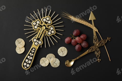 Preview: Cross, liturgical bread, grape and cutlery on black background, top view