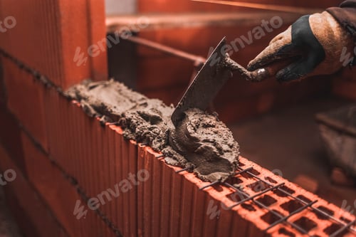 Preview: Bricklayer puts bricks to make a wall