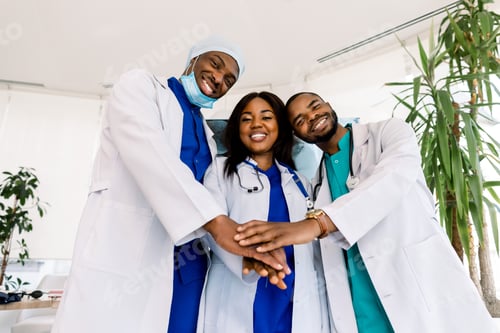 Preview: Three African young doctors coordinate stacking hands together at hospital, Concept Teamwork, happy