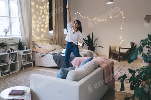 Preview: Cheerful woman listening to music in bedroom