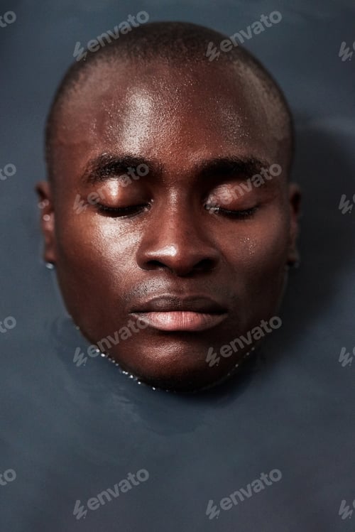 Preview: Shot of a handsome young man submerged in a bath filled with dark water