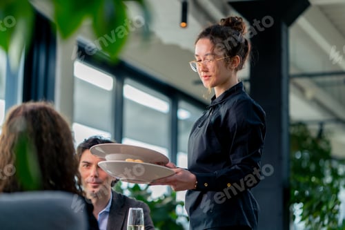 Preview: girl waiter serves orders to guests the concept of hospitality and service in high-class restaurant