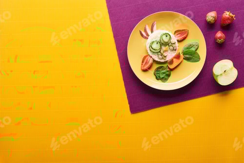 Preview: Top View of Plate With Fancy Cow Made of Food on Purple And Orange Background