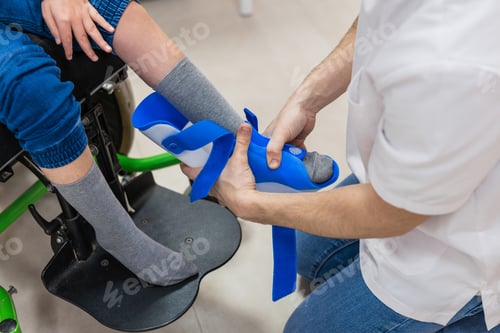Preview: Therapist fitting dafo orthosis on child's leg
