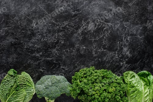 Preview: top view of broccoli, savoy cabbage and parsley on concrete table, healthy eating concept