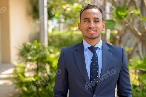 Preview: African businessman wearing suit and smiling outdoors