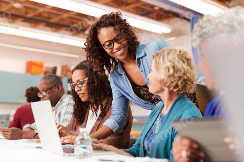 Preview: Teacher Helping Group Of Retired Senior Women Attending IT Class In Community Centre