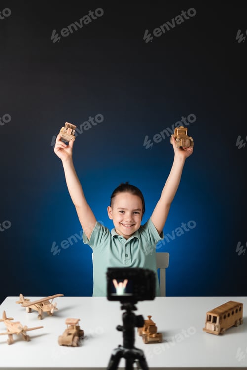 Preview: School boy streaming on social media about wooden toys. Z generation