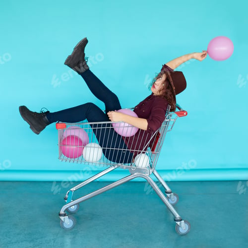 Preview: Beautiful brunette girl sitting in shopping cart