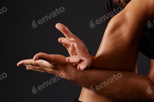 Preview: handsome male masseur doing a massage on a girl's leg on a black background