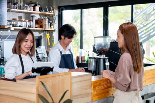 Preview: Asian barista or coffee maker receive the order from customer woman