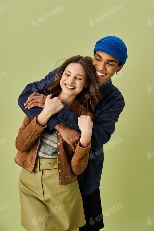Preview: Young couple enjoying autumn fashion trends while playfully embracing in vibrant fall attire
