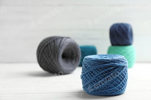 Preview: Clews of knitting threads on table, space for text. Sewing stuff