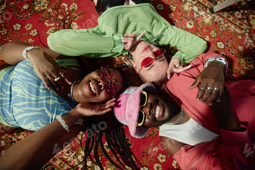 Preview: Top View Three Trendy People Lying on Ornate Carpet