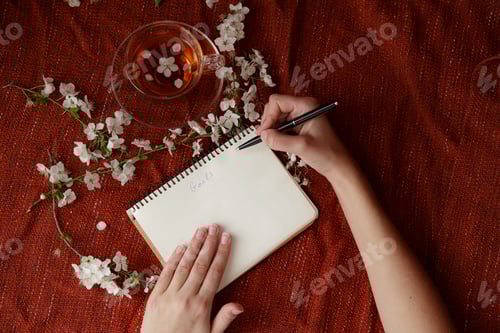 Preview: Woman's hands holding pen and spiral notepad as mockup